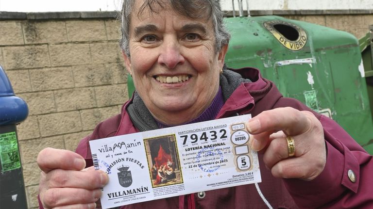 Una vecina de Villaman�n muestra una de las participaciones premiadas con el gordo de Navidad