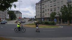 Ciclista y patinete el�ctrico en la rotonda de la carretera de Castilla con la avenida Nicasio P�rez, uno de los puntos negros del tr�fico en Ferrol.