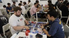 Varios jugadores disputan partidas en la tienda Mazinger de Vigo, uno de ellos mientras la graba. 