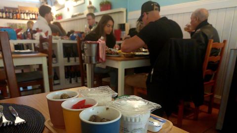 Imagen del interior de una tasca portuguesa, con el  couvert  sobre la mesa libre.