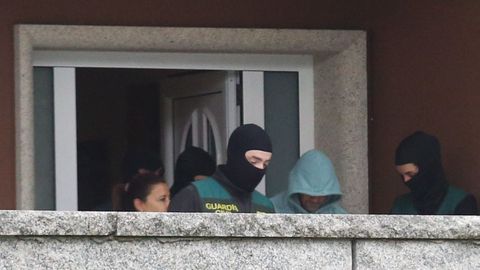 Uno de los detenidos, con capucha, en la casa registrada en Rubi�ns.