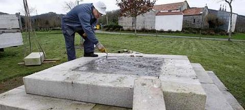 Un trabajador daba los últimos toques a la base del cruceiro, situado en el campo de la fiesta, a pocos metros de la iglesia.