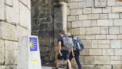 Dos peregrinos, entrando en el recinto amurallado de Lugo este martes por la Porta de San Pedro 