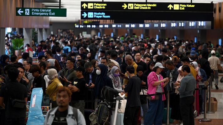 Multitud de viajeros esperan en la cola del aeropuerto internacional Soekarno-Hatta, en Yakarta.