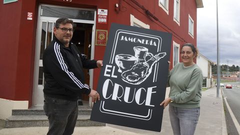 C�sar y Diana, portando la pancarta de la jamoner�a El Cruce en la nueva ubicaci�n .