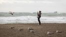 Una mujer fotograf�a este s�bado la playa de la malagueta, en alerta naranja por lluvias y fen�menos costeros