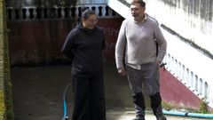 Aguas fecales en la calle Noria de Cangas con  una vecina y el encargado de la empresa San Vicente que se dedica a achicar el garaje