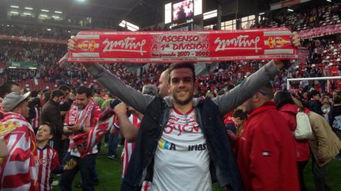 Un aficionado celebra la permanencia con la bufanda del Sporting sobre el csped de El Molinn