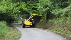 Trabajos de desbroce en una v�a asfaltada de Silleda.