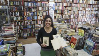 Marta Fojo, en la librer&iacute;a Follas Vellas de Santiago, con primeras ediciones de obras de Castelao y de Cunqueiro.