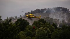 Helic�ptero durante las labores de extinci�n del incendio forestal en Grado, Asturias