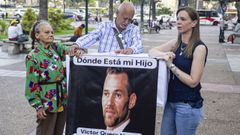 La madre de V�ctor Hugo Quero (izquierda) sostiene un cartel con el rostro de su hijo junto a los abogados del Foro Penal, Jes�s Marcano y Stefan�a Migiorini.