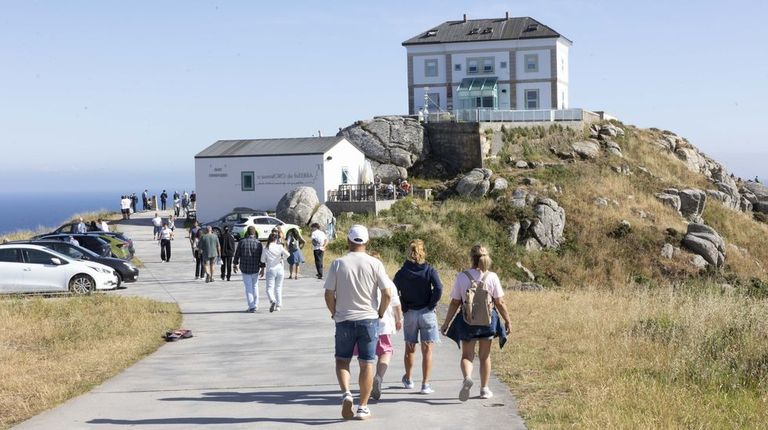 Visitantes en el entorno del cabo Fisterra, uno de los puntos m&aacute;s visitados de la Costa da Morte