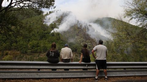 Unos vecinos observan desde la orilla ourensana del Sil el avance de las llamas ladera arriba de San Cosmede