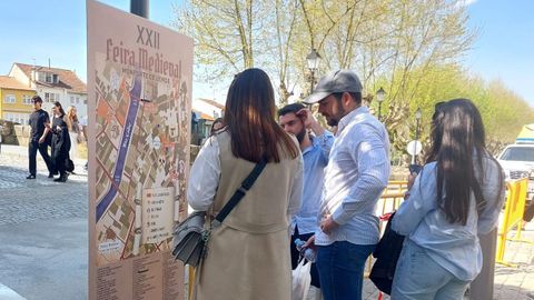 Un grupo de visitantes consulta un plano del recinto de la Feira Medieval