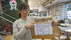Sheila Silva, de Lola & L�a, con el cartel de la oferta�de empleo que colgaron en su local de Pontevedra antes de abrir