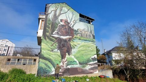 El artista lucense Diego As, terminando el mural en Becerre
