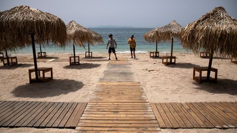 Trabajadores instalan pasillos de madera en una playa de Atenas que reabrir este sbado