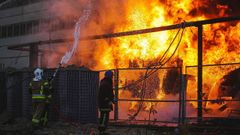 Dos bomberos tratan de extinguir un incendio en una estaci�n el�ctrica de Kiev