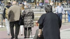 Personas mayores paseando por el entorno del muelle ferrolano de Curuxeiras.
