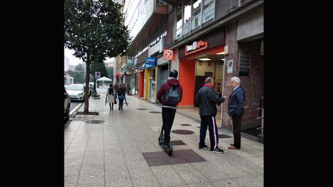 Un usuario recorre en patinete la calle Valent�n Masip de Oviedo