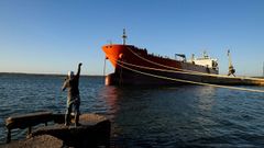 Un hombre pesca ante un buque tanquero cubano en los muelles de Matanzas (Cuba)