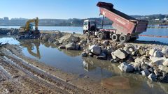 Camiones desplazan material para cerrar el recinto de Oleiros