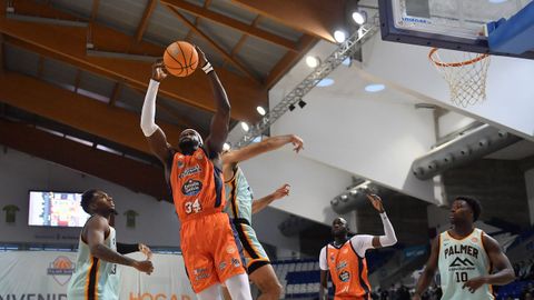 Mus Barro atrapando el bal&oacute;n entre dos jugadores del Palmer Basket