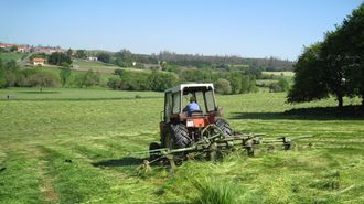 Tractor cortando hierba en una foto de archivo