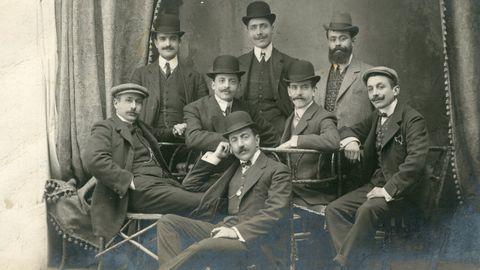 Un grupo de caballeros, con los diferentes sombreros y gorras de la poca, que no han cambiado demasiado