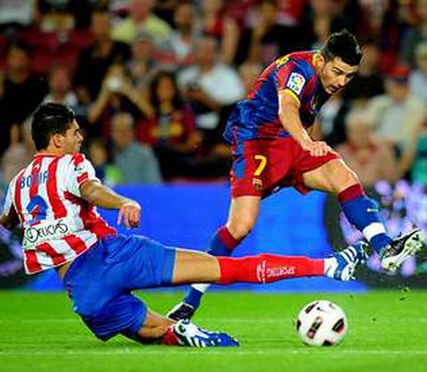 El asturiano Villa chuta a puerta ante la oposici�n del ex barcelonista Bot�a