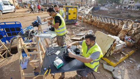 Trabajadores de una empresa de telecomunicaciones reparan la fibra óptica en Paiporta, zona cero de la dana en Valencia