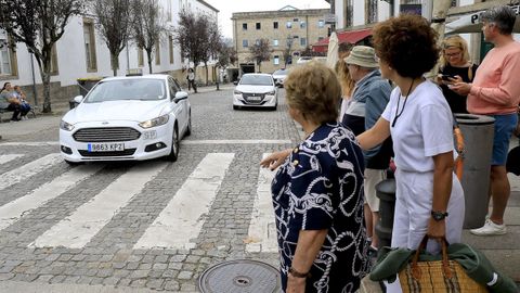 Viajeras intentan parar un taxi en la parada de Porta Faxeira.