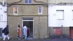 Vecinos accediendo al portal del piso que se incendi�, envueltos en mantas.