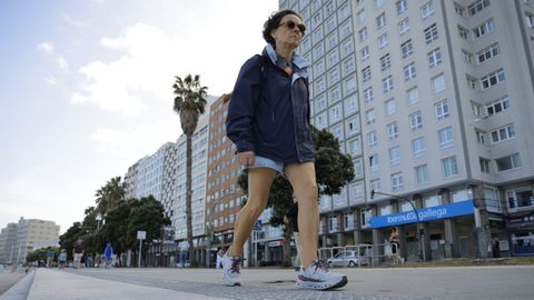 Una mujer camina por el paseo martimo en Riazor