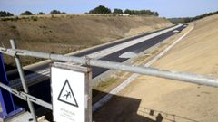 En la imagen, del pasado 26 de septiembre, una fase del tramo de la autov�a A-54 pendiente de abrir entre Melide y Arz�a, ya asfaltado y con monta�as de gravilla sobre la calzada. Quedan por aplicar las capas de rodadura definitivas, la se�alizaci�n, y tambi�n los remates en cunetas y canalizaciones.