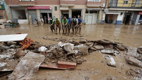 Vecinos de Paiporta limpian el lodo de una de sus calles