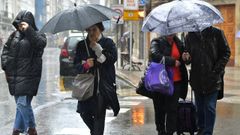 Imagen de archivo de�transe�ntes protegi�ndose de la lluvia en A Coru�a.