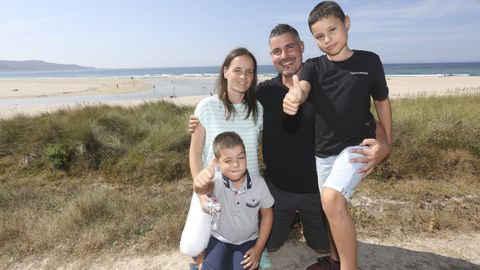 Alberto, con sus padres y su hermano menor, este martes en la playa de Traba (Laxe)