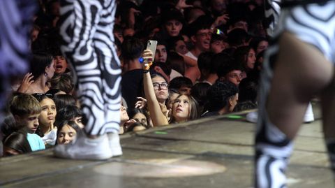 Una chica se hace una foto en primera fila durante la actuacin de la orquesta Panorama en Monforte