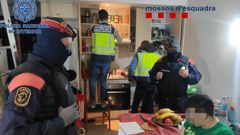 Agentes de la Polic�a Nacional y de los Mossos d'Esquadra trabajando juntos en el registro del domicilio de presuntos delincuentes