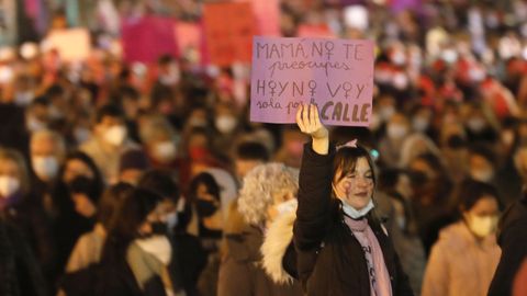 Una joven sostiene una pancarta que dice Mam, no te preocupes, hoy no voy sola por la calle.