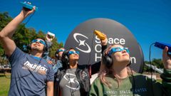 Un grupo de personas utiliza los dispositivos LightSound durante un eclipse