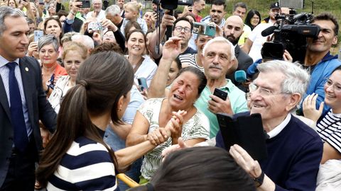 Una mujer saluda emocionada a la reina en el exterior del colegio.