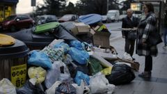 Dos personas observan basura acumulada en la avenida de Oza