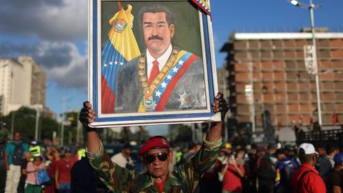 Un hombre uniformado muestra un retrato de Maduro durante unos ejercicios militares en Caracas