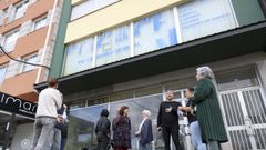 Vecinos frente al edificio abandonado que les causa molestias en sus viviendas. 