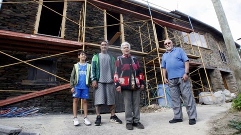 Emilio R�o y Carmen Marcos con su hijo y su nieto, frente a una de las casas a�n en reconstrucci�n