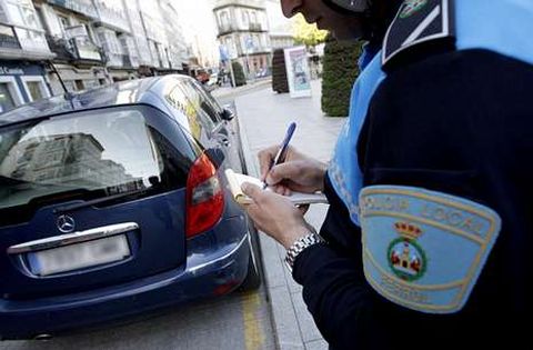 Polic�a local multando un veh�culo mal aparcado, en una foto de archivo.