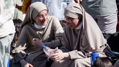 Dos religiosas charlan mientras guardan sitio de cara a la Vigilia.